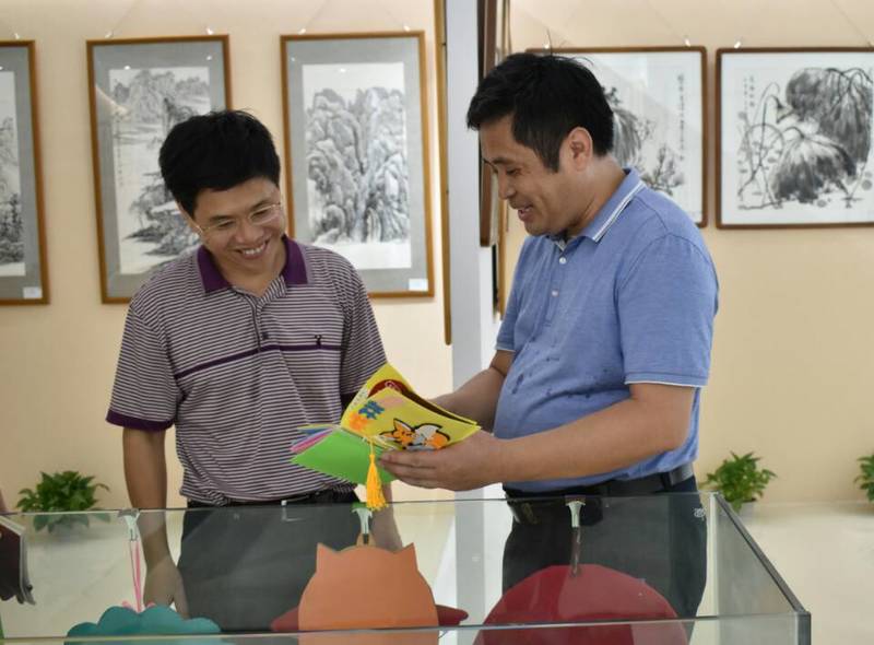 2018年9月14日校长韩峻峰（左）参观ok138cn太阳集团第一届师生书画作品展。