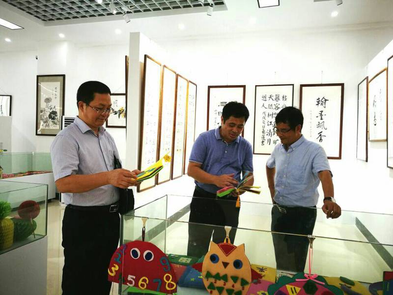 2018年9月10日学校党委陈锦山副书记（右）参观ok138cn太阳集团第一届师生书画作品展。