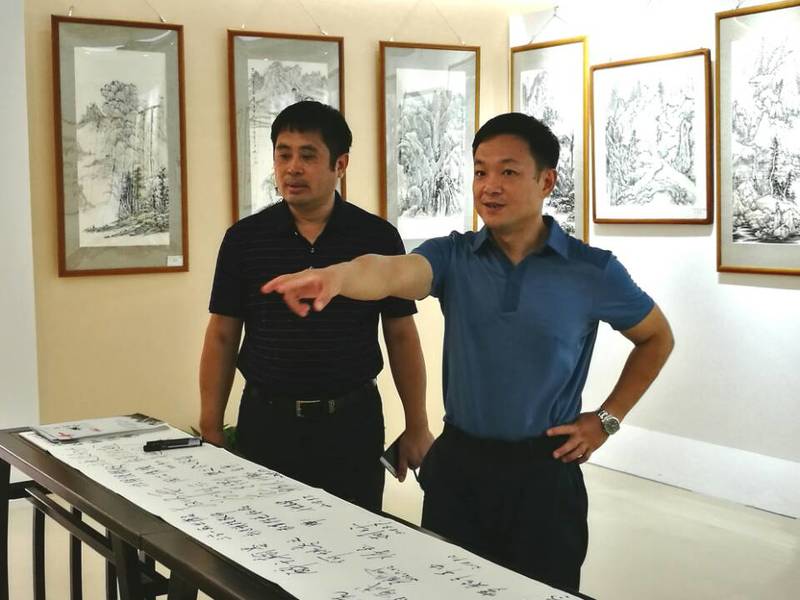 2018年9月11日学校党委陈湘如副书记（右）参观ok138cn太阳集团第一届师生书画作品展。
